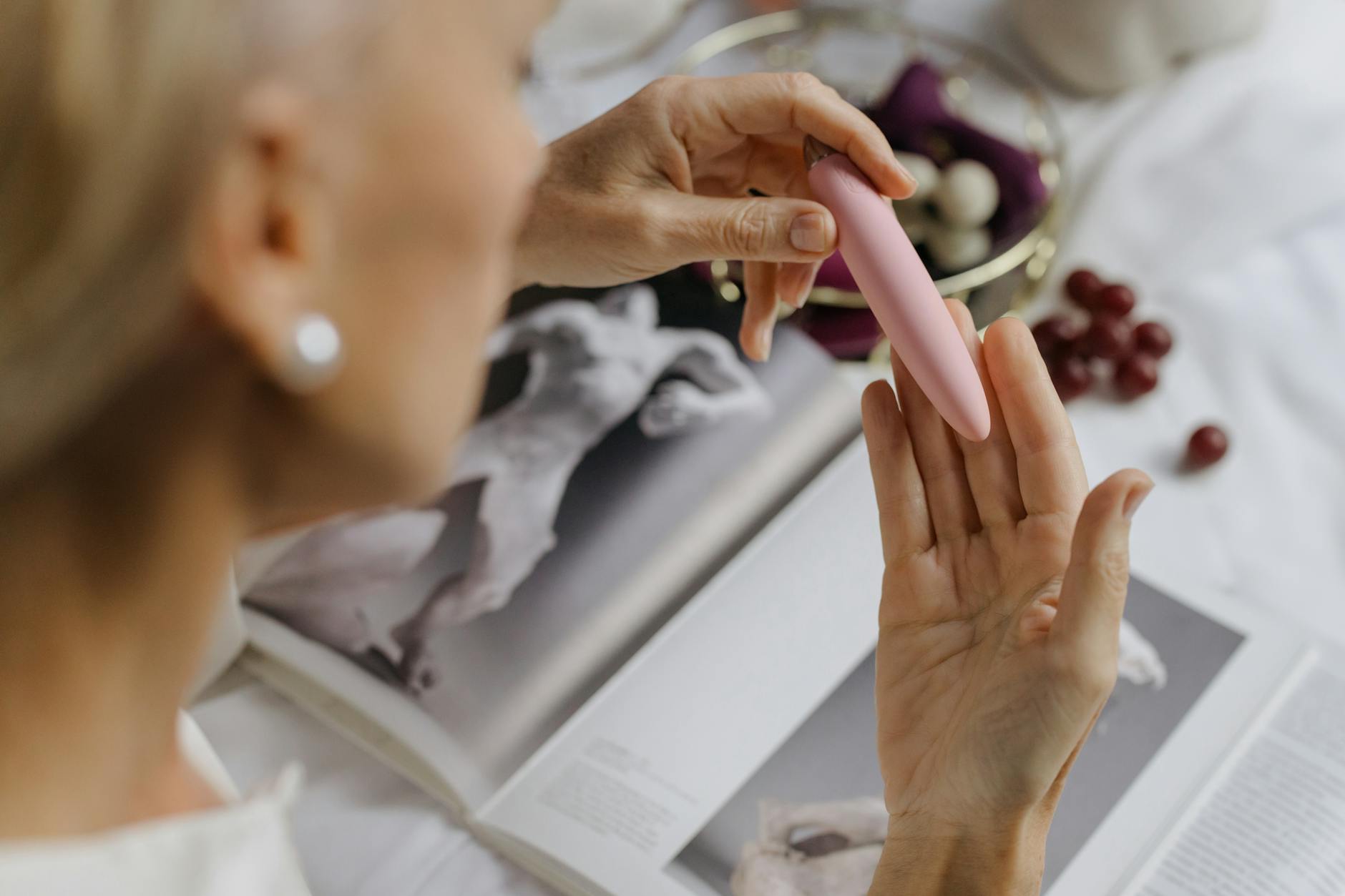 Close-up of a person holding a lemon-colored vibrator with intention and care